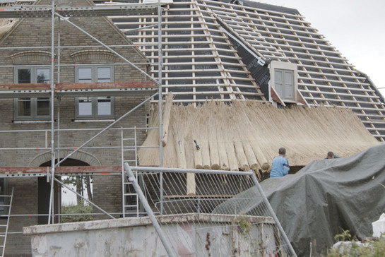 Ein Haus wird mit Reetdach verkleidet