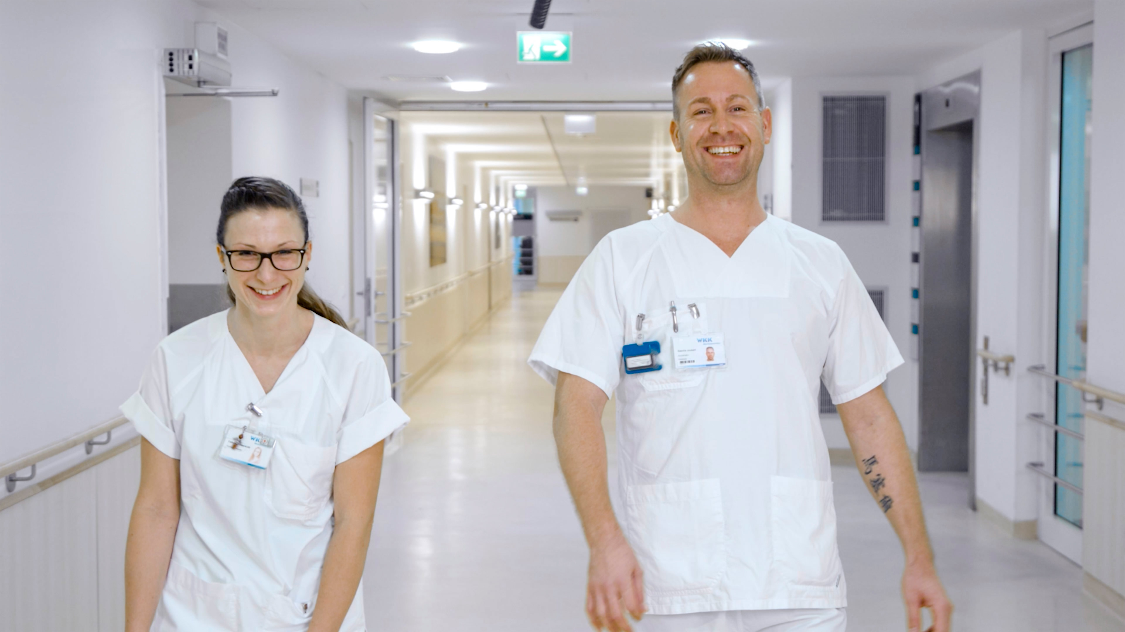 Zwei Krankenpfleger gehen einen Flur entlang